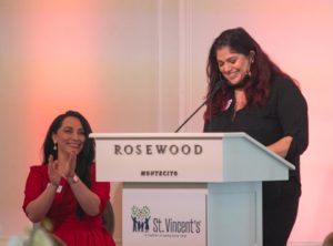 Guest speaker Rosalinda (last name not given), a graduate of St. Vincent's Family Strengthening Program, speaks while Regina Ruiza, St. Vincent's Vice President of Development & Marketing, applauds during the St. Vincent’s fashion show at the Rosewood Miramar Hotel on Saturday, November 27, 2021. (Kenneth Song/News-Press)